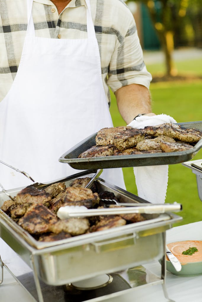 Deliciously grilled steaks being served outdoors at a barbecue event.