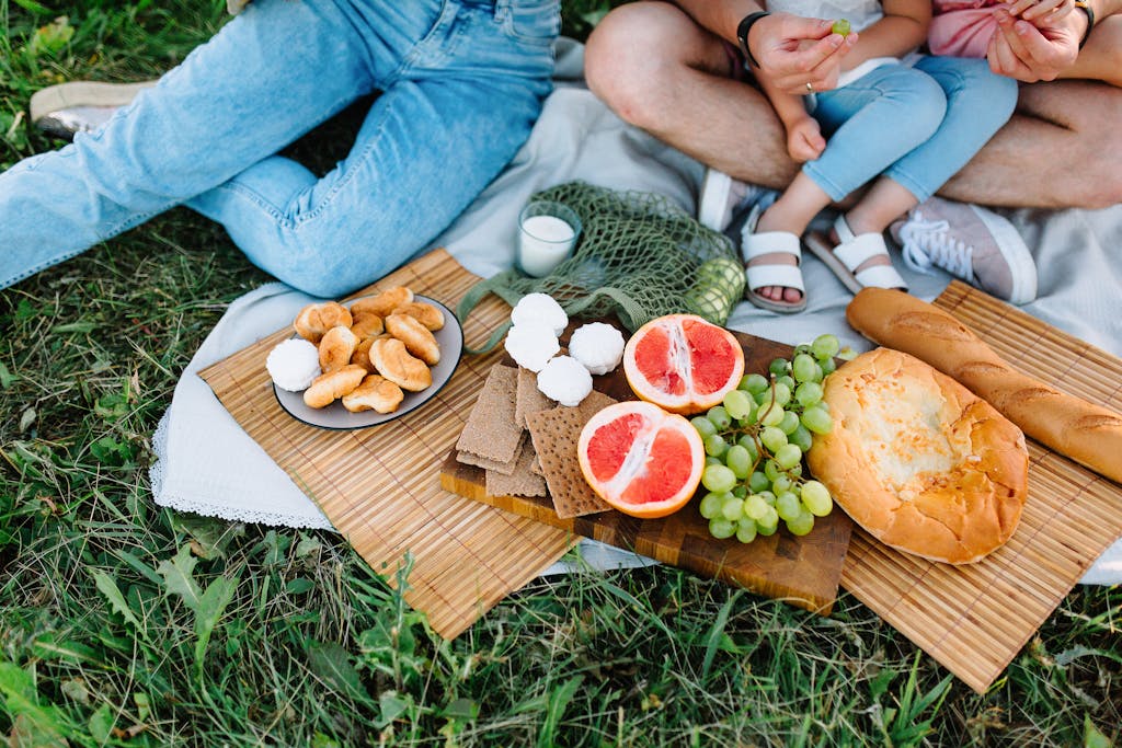 Enjoy a summer picnic featuring fresh grapes, grapefruit, and assorted breads.
