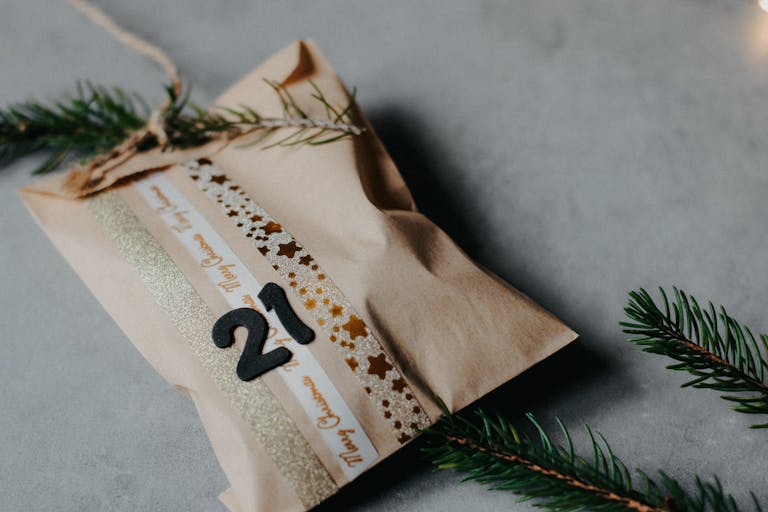 Festively decorated brown paper bag holding a gift for a homemade christmas advent calendar