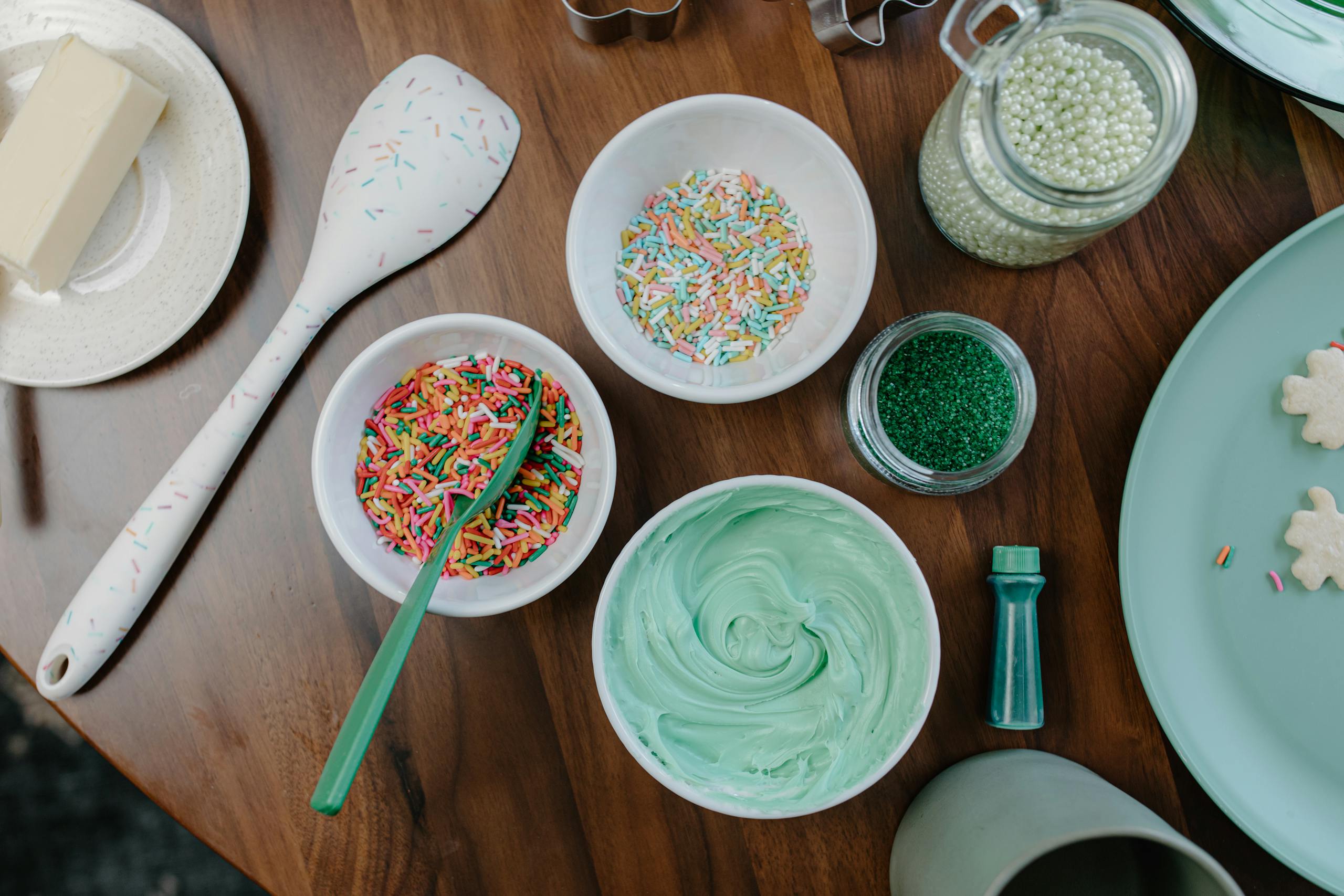 sprinkles and icing on a wooden table, perfect for dessert preparation.