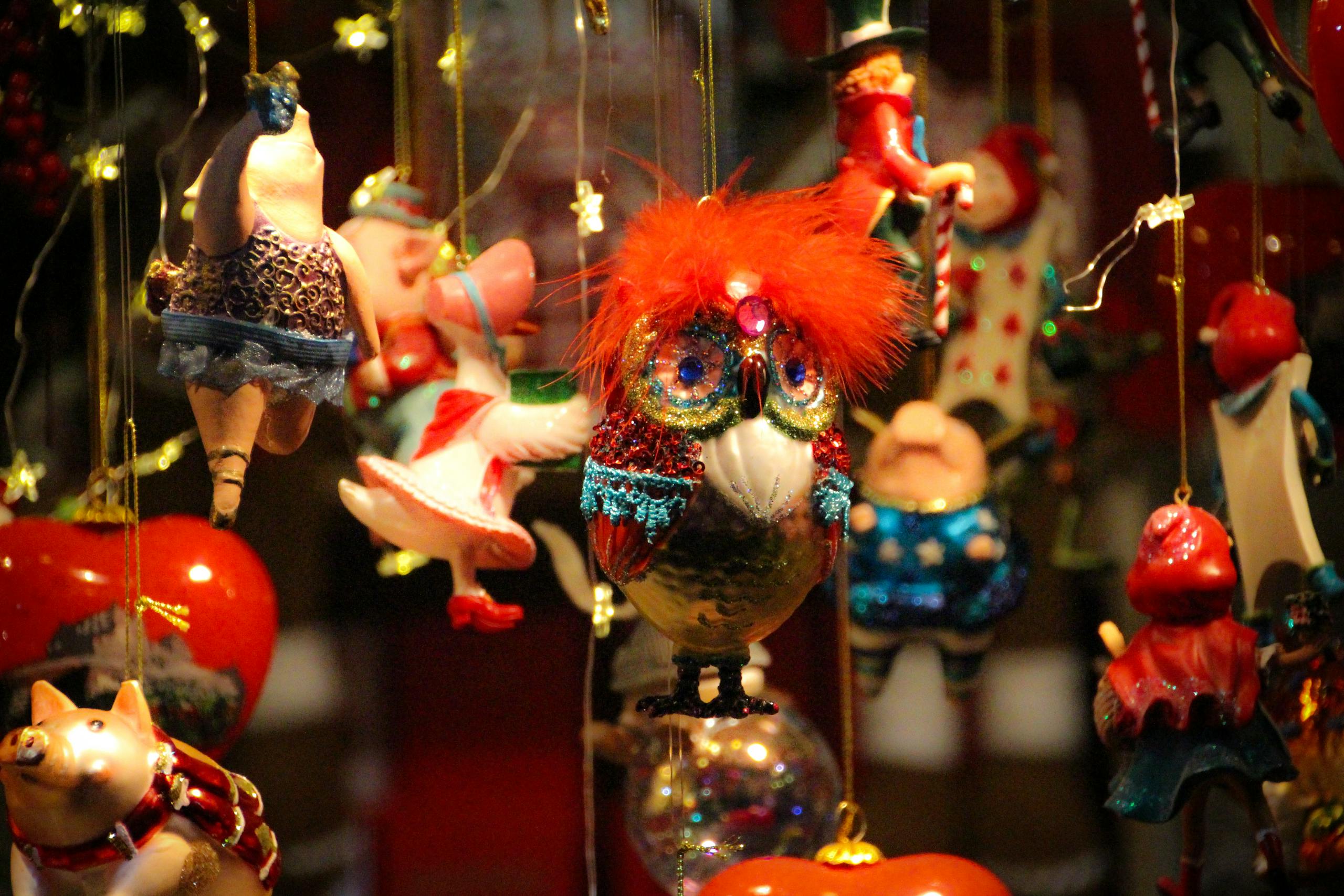 A vibrant display of colorful hanging Christmas decorations featuring various whimsical figures and ornaments.