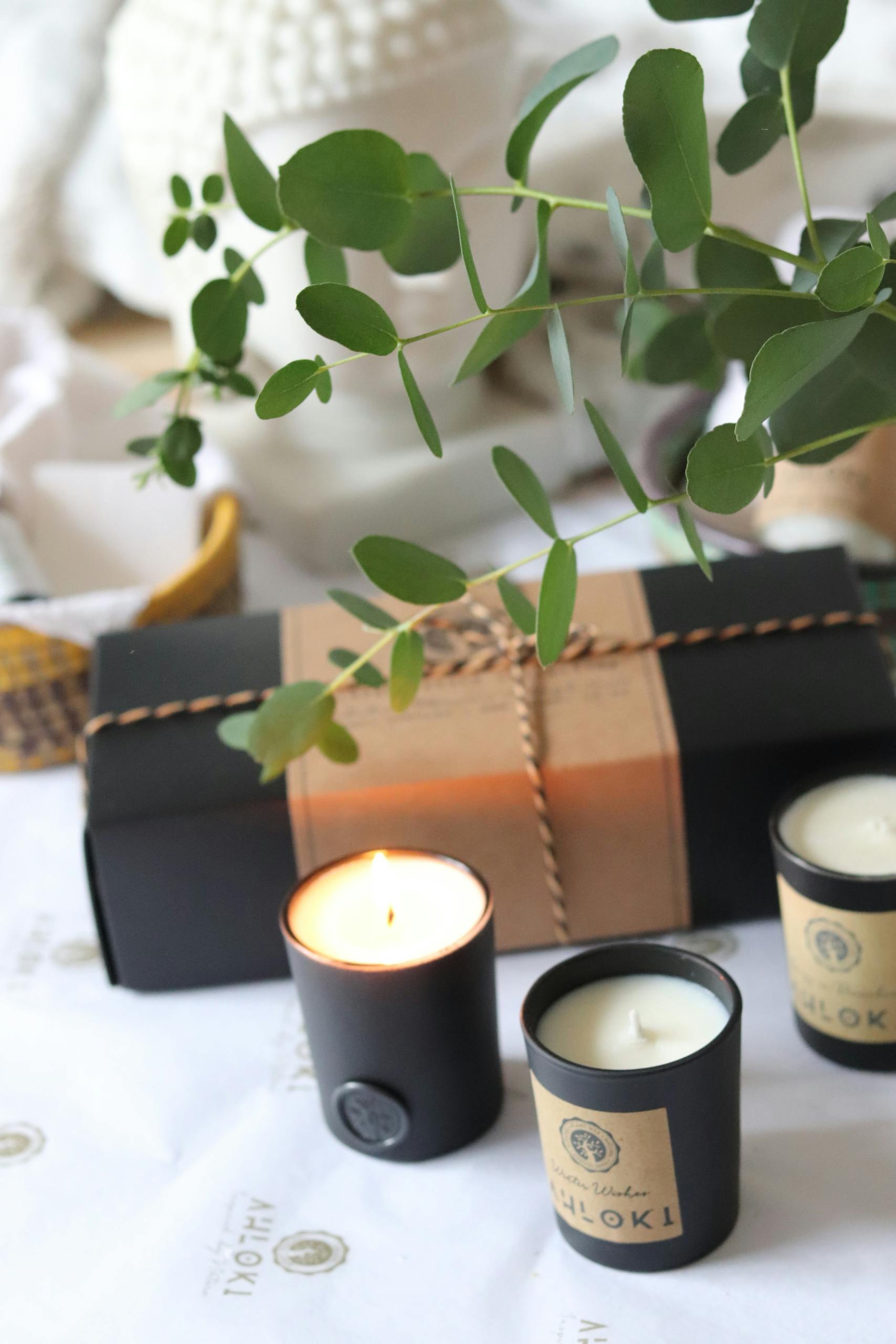 Luxurious candles with eucalyptus on a gift-wrapped box, perfect for relaxation.