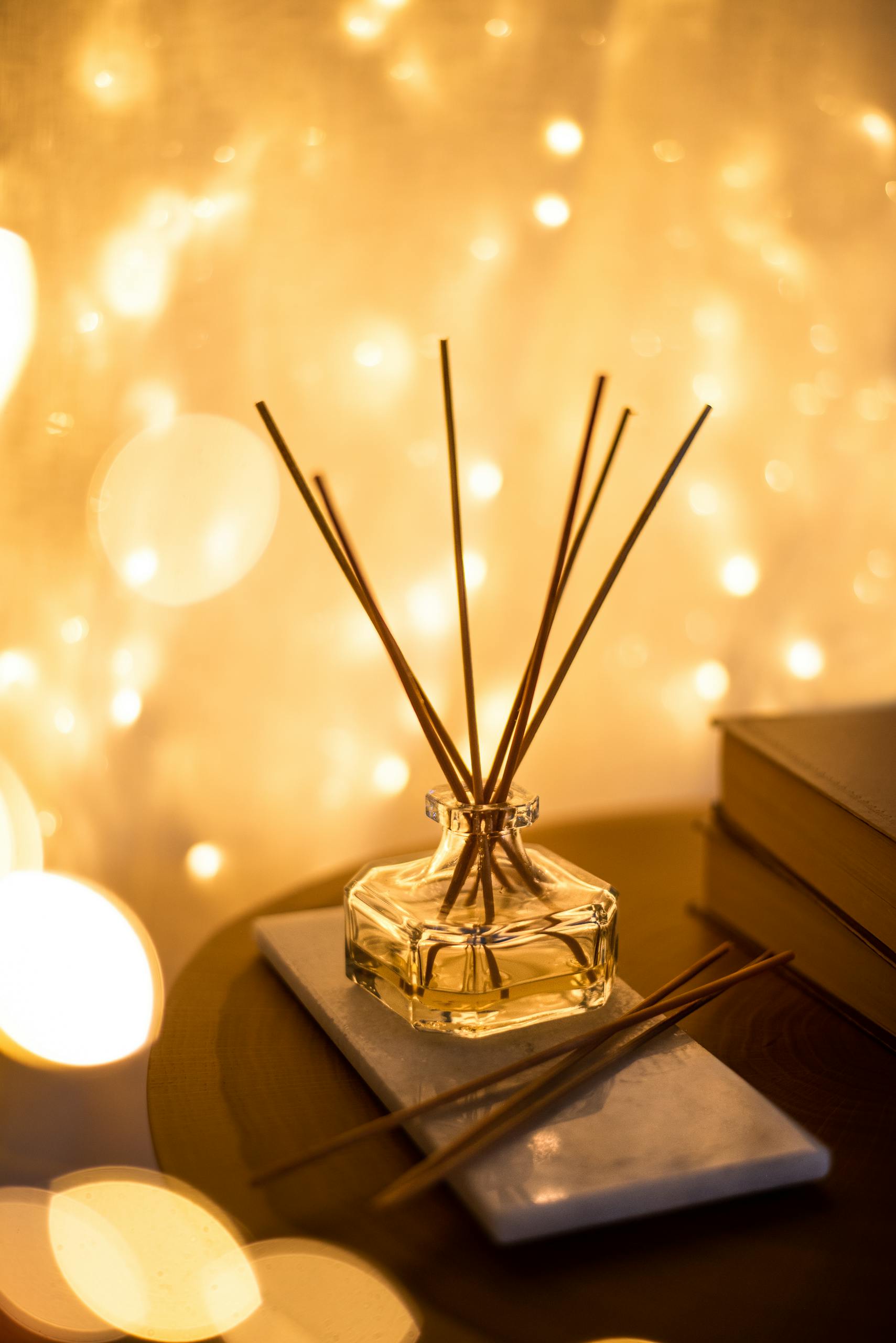 A decorative reed diffuser with a bokeh light background, creating a warm atmosphere.