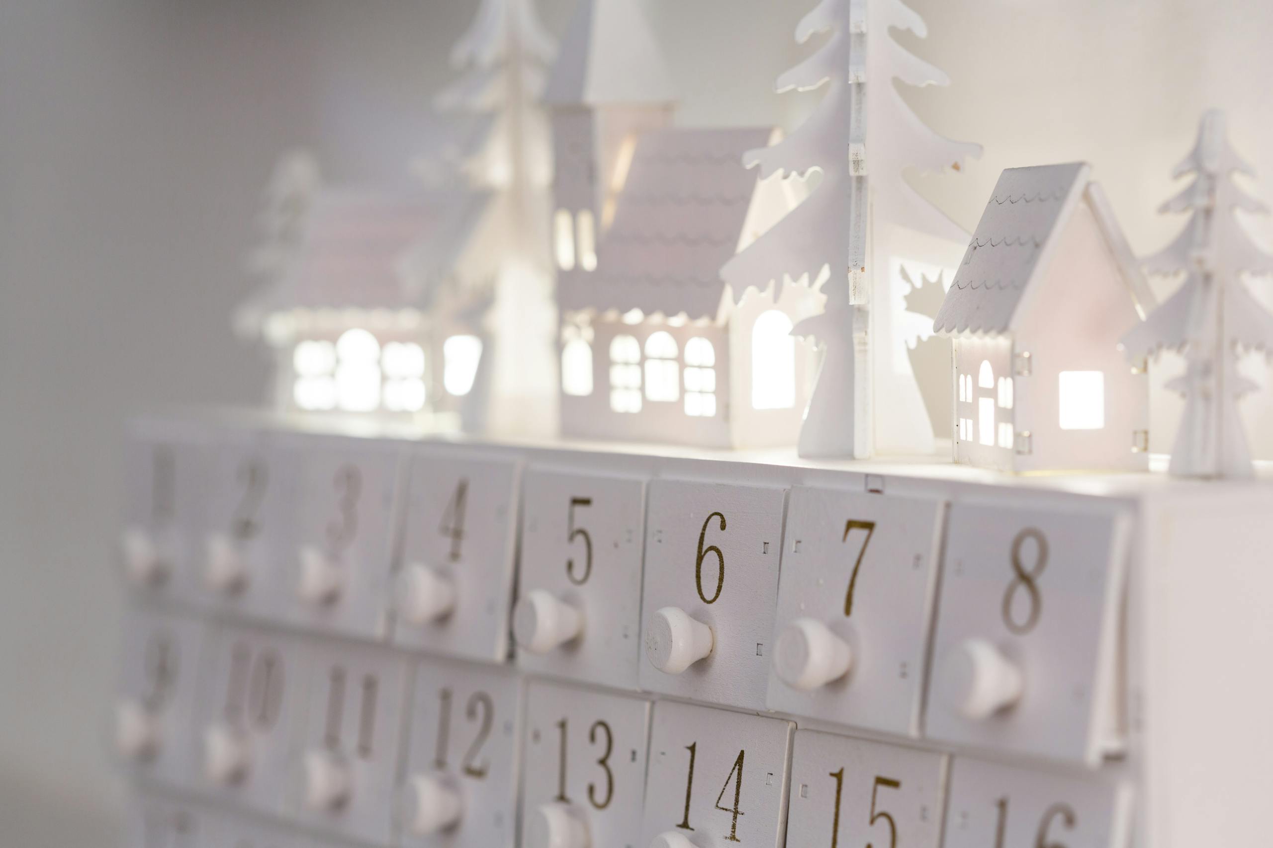 Beautiful minimalist advent calendar with illuminated houses and numbers for winter decor and festive ambiance.