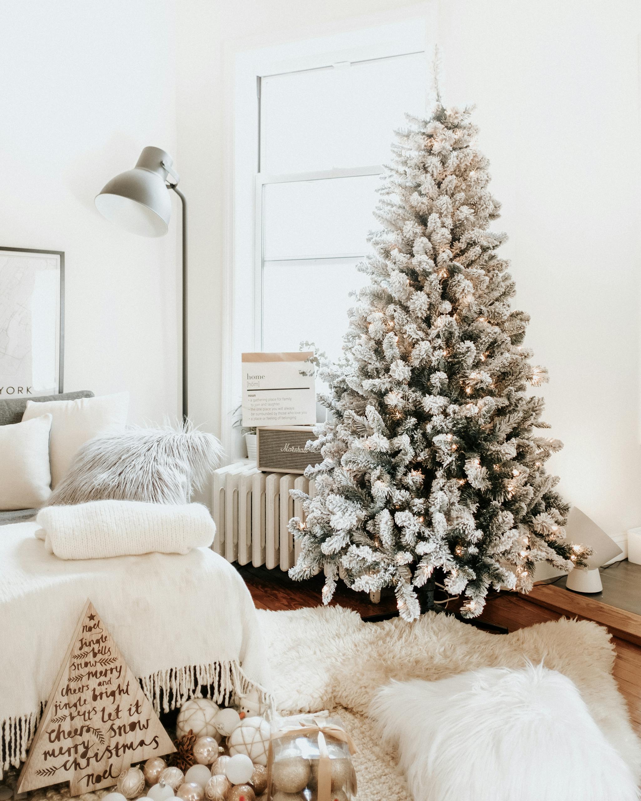 Charming home interior decorated for Christmas with a snow-flocked tree and cozy furnishings.
