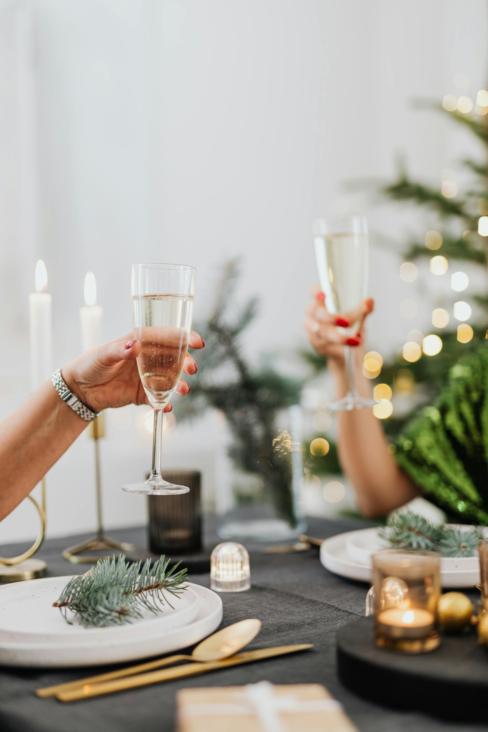 Elegant holiday celebration with a champagne toast at a decorated table.