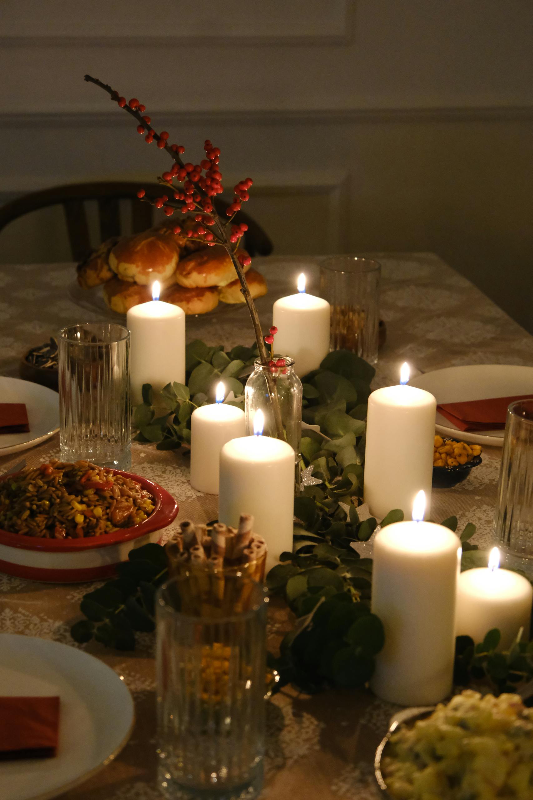 Warm candlelit dinner setting with festive and elegant decorations on a table, ideal for holiday celebrations.