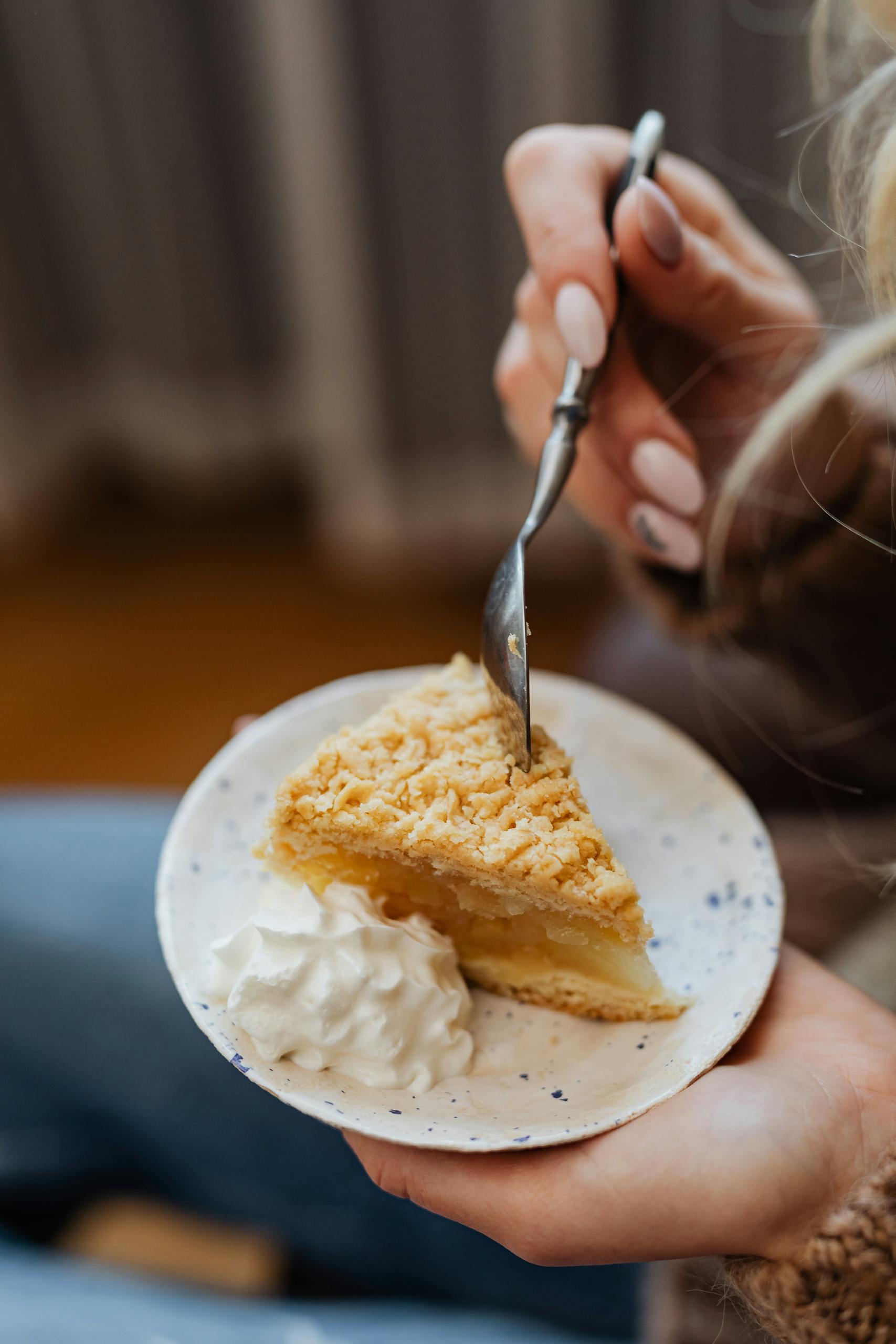 A delectable close-up of a slice of apple pie with whipped cream on a plate.