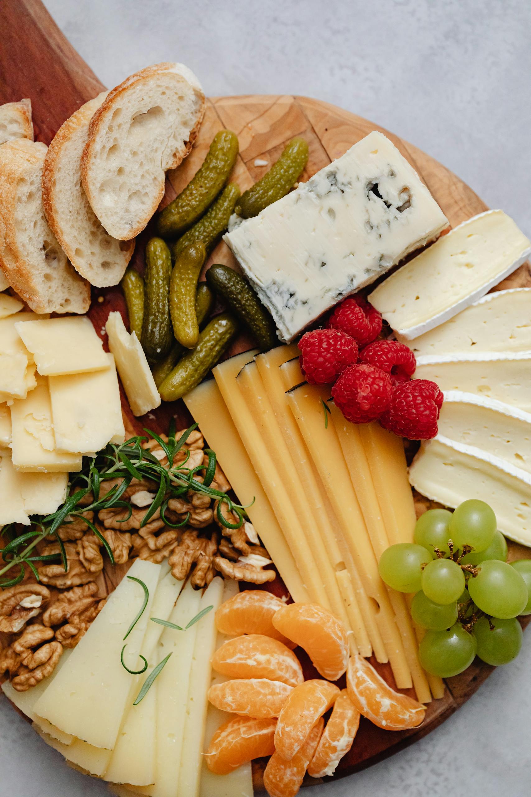 A vibrant assortment of cheeses, fruits, and nuts on a wooden board. Perfect for gourmet snacking.