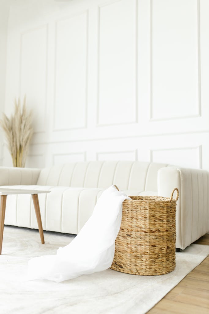 Bright minimalist interior with a white sofa and wicker basket accenting the natural decor.