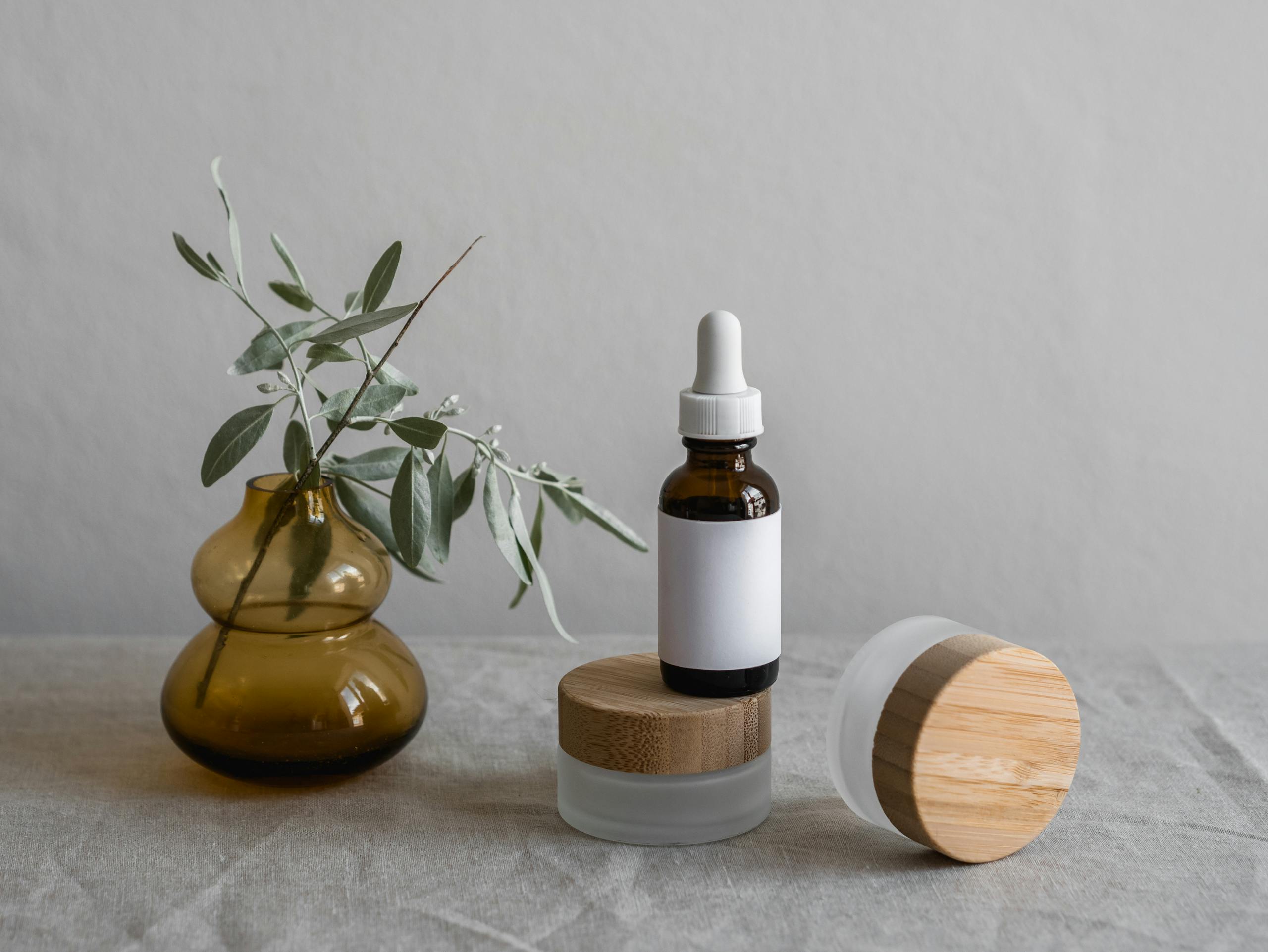 Brown glass dropper bottle with plants and minimalist decor.