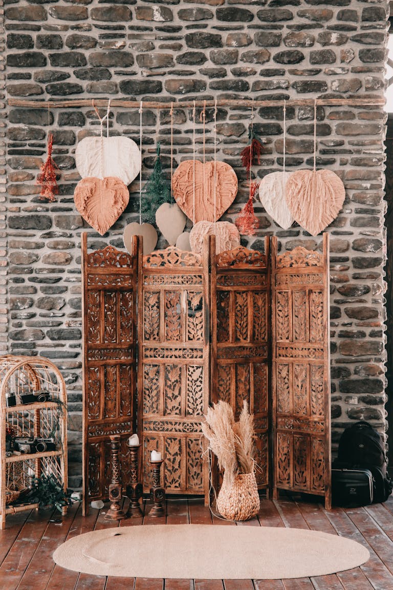 Cozy rustic interior featuring a wooden divider with heart decorations and stone wall background.