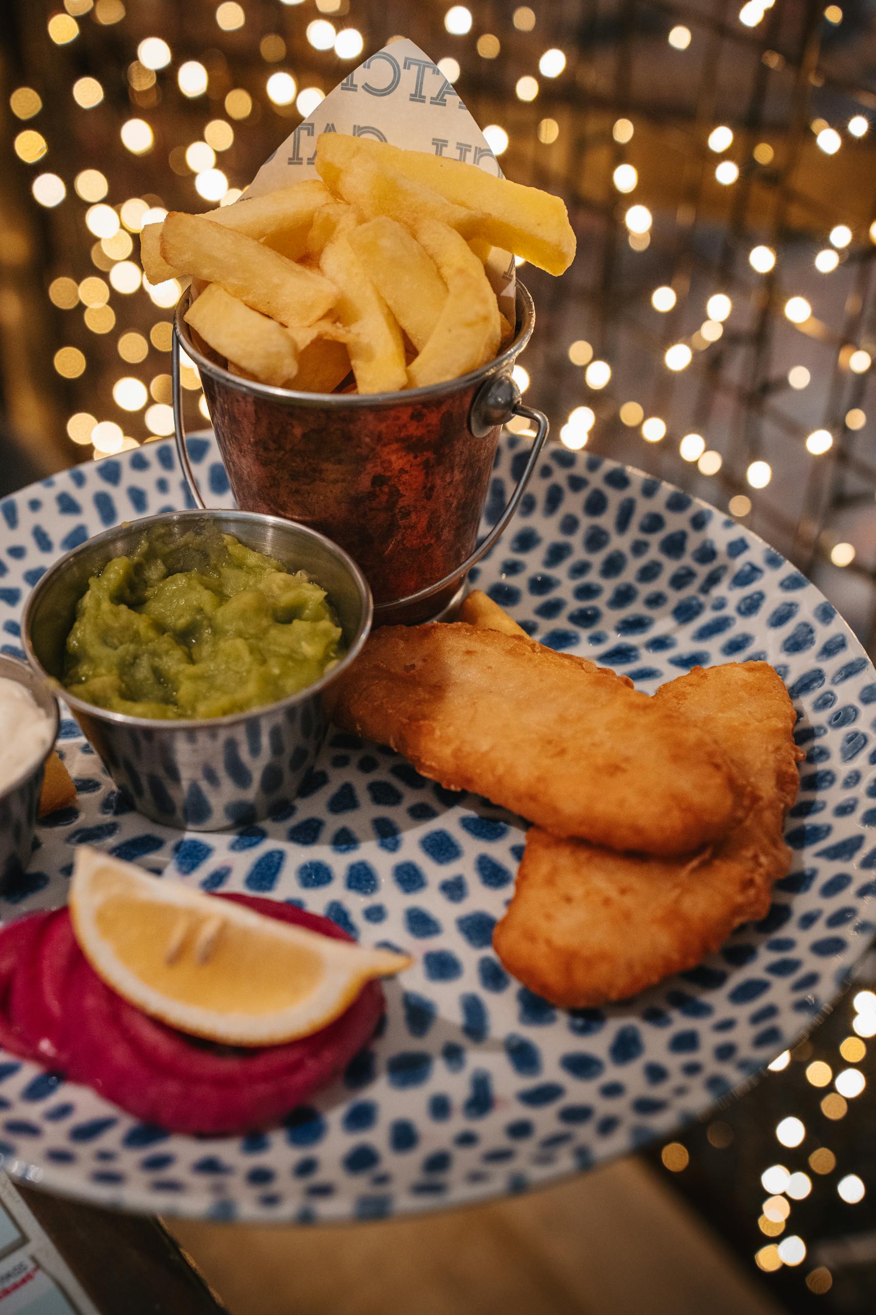 Delicious fish and chips platter with mushy peas, perfect for a cozy meal.
