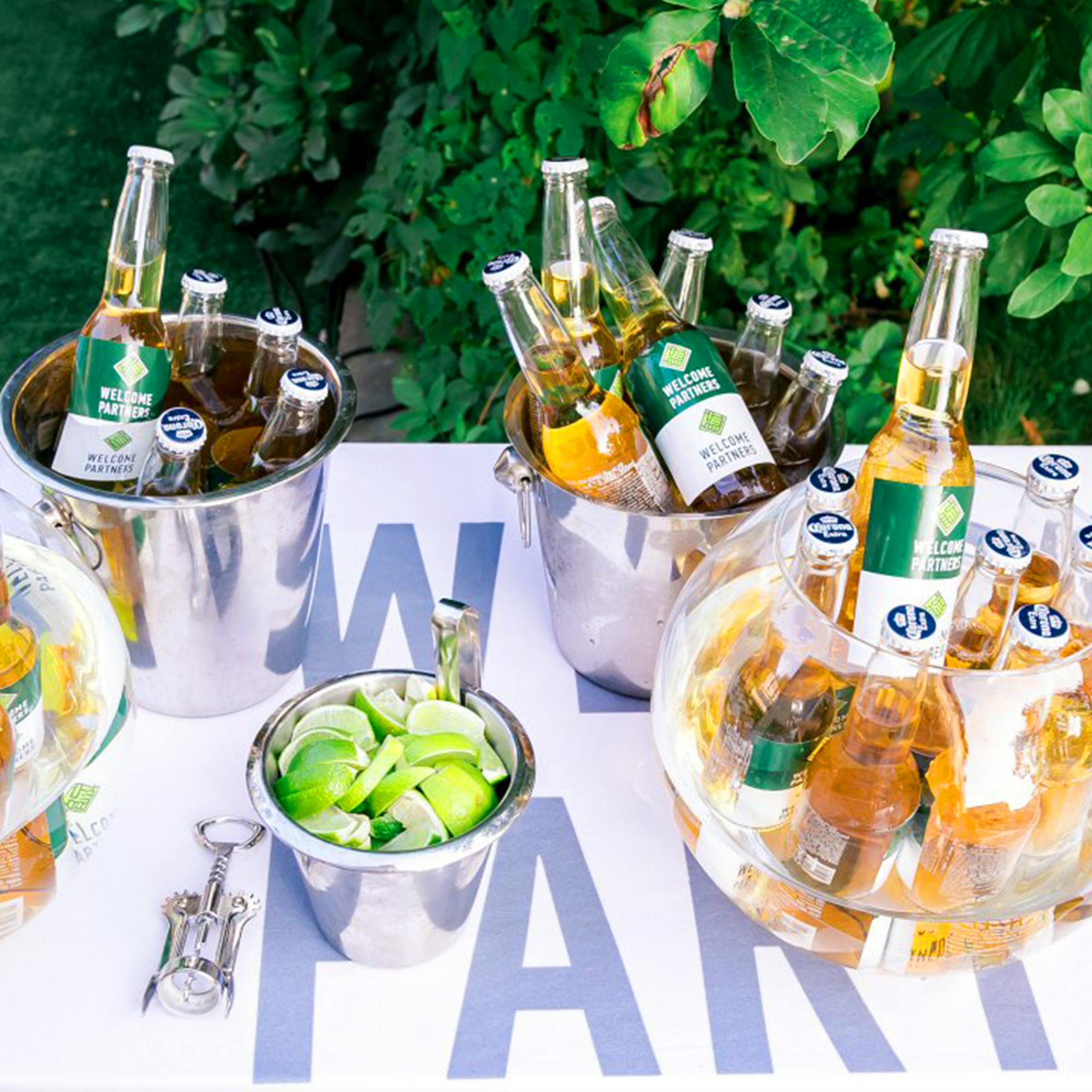 Ice-cold beers in shiny buckets and fresh limes centerpiece for a party atmosphere.