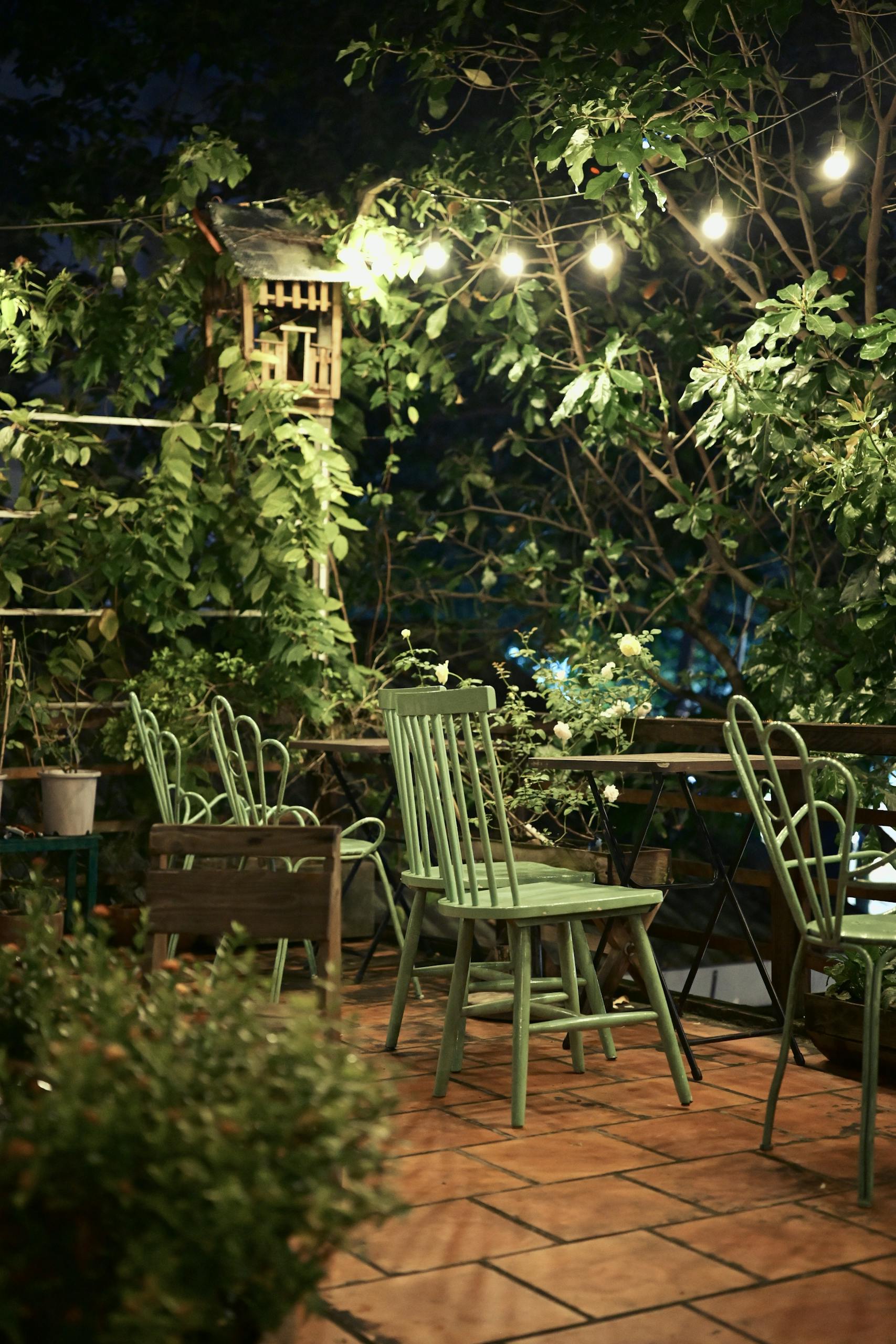 Inviting outdoor patio with chairs and string lights, perfect for a night gathering.