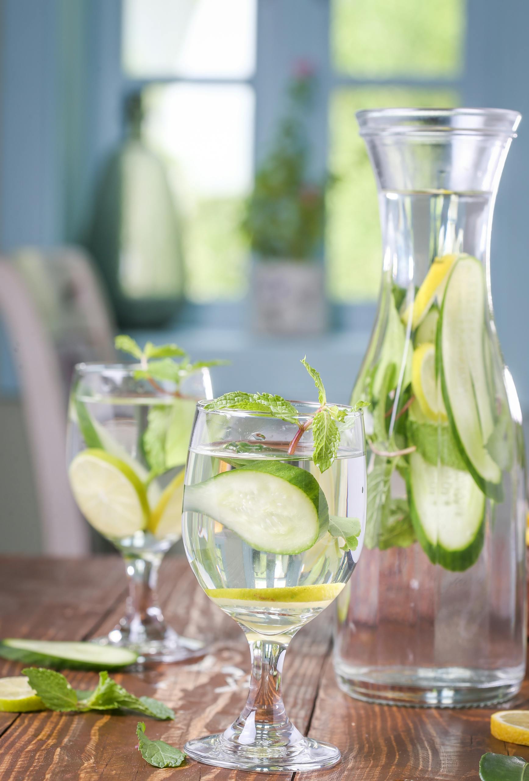 Lemon cucumber infused water with mint leaves in glassware for a healthy refreshment.