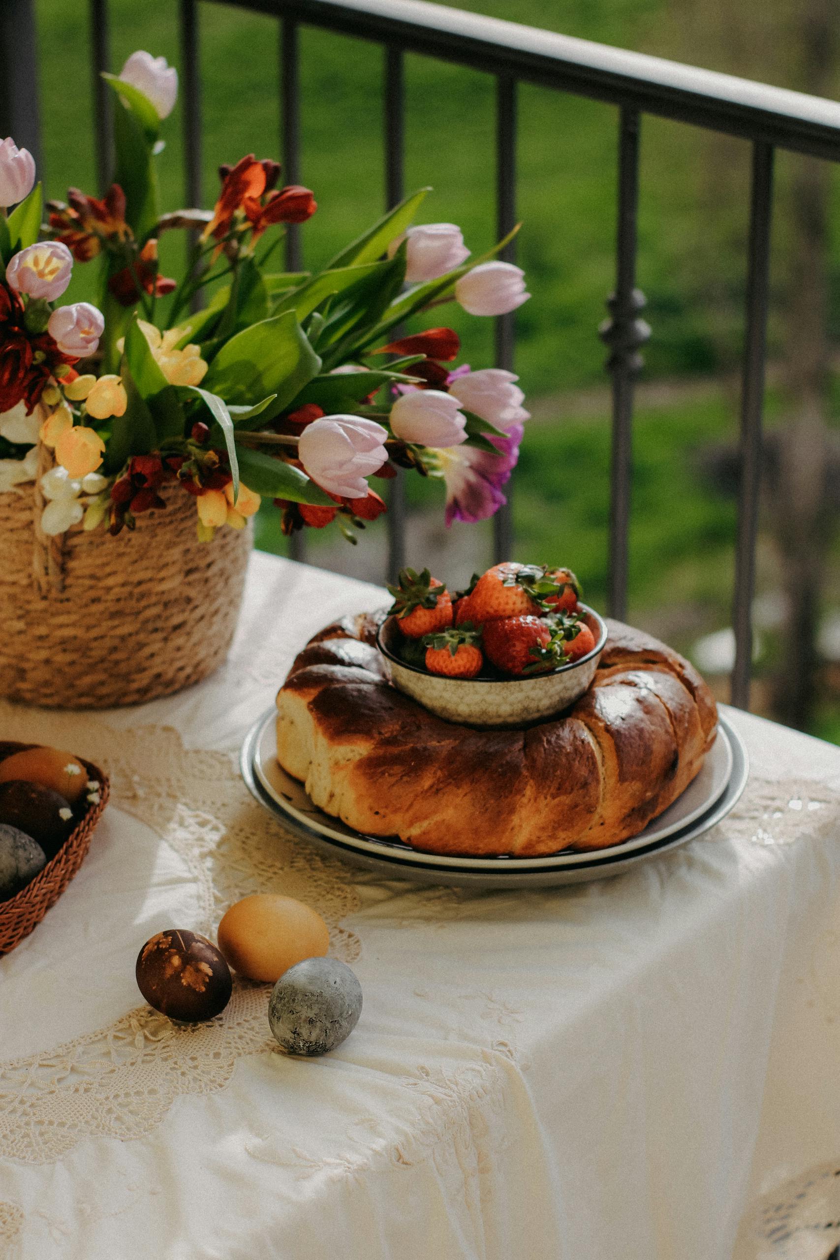 Lush spring brunch scene with Easter cake, colorful eggs, and fresh tulip bouquet.