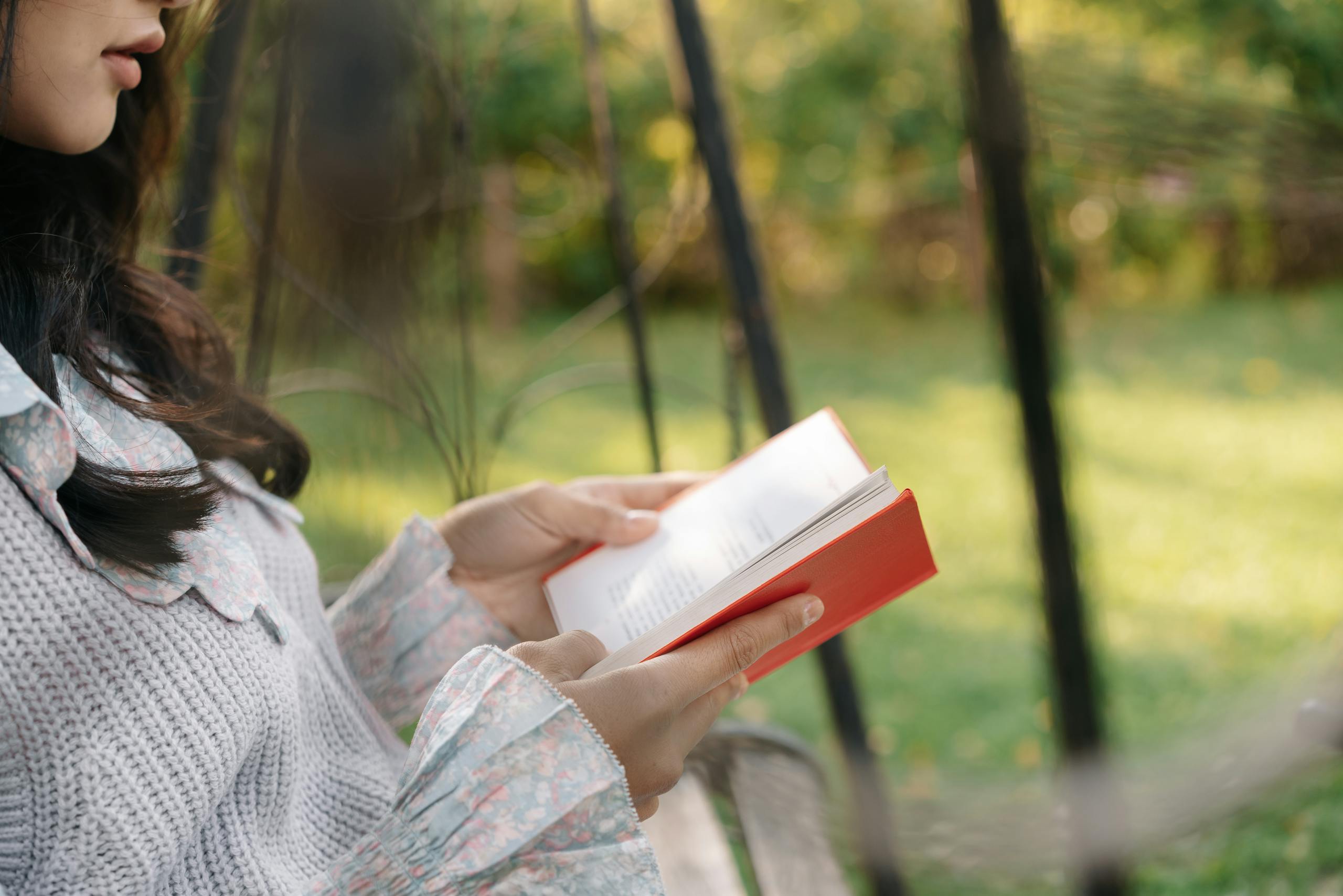 Woman enjoys a book in a tranquil garden, showcasing leisure and relaxation.