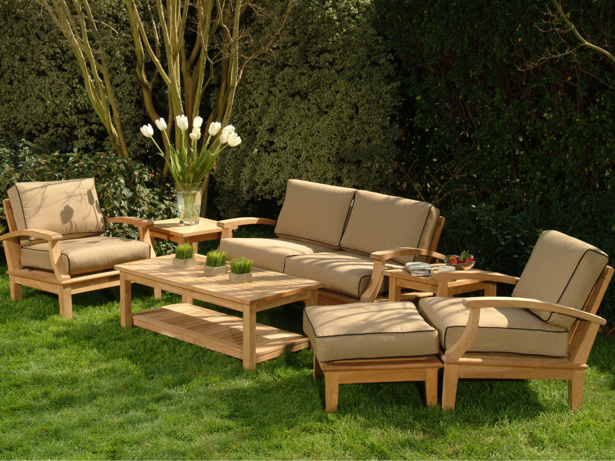 Beige Garden Patio furniture set on a green lawn in the summer time with a vase of fresh flowers on  a garden table 