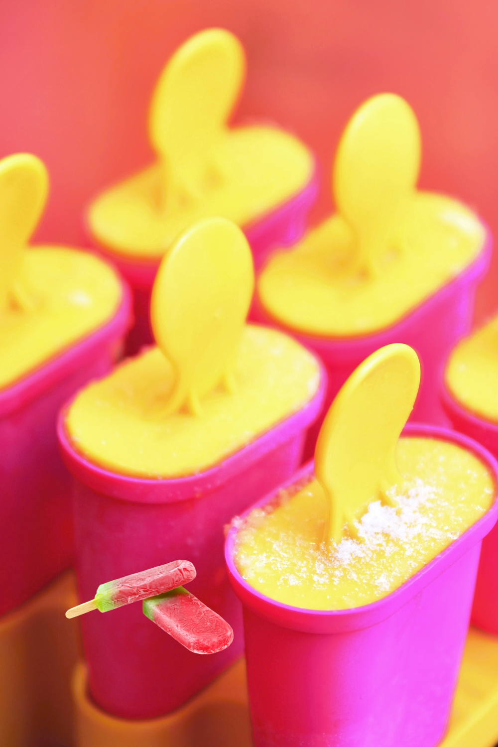 Homemade colourful fruit ice lollies in pink lolly moulds