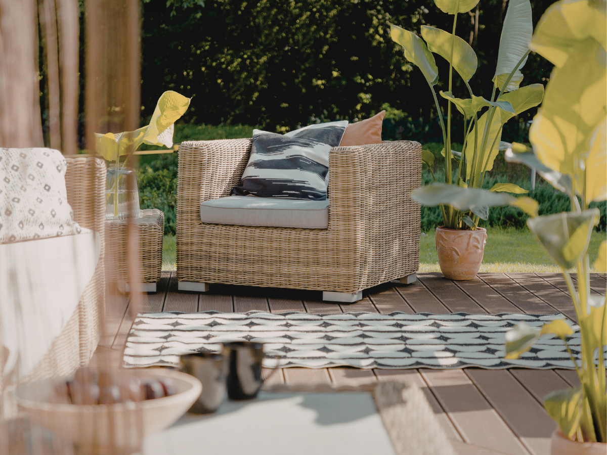 Rattan Garden Chair on a small patio with a black and white outdoor rug