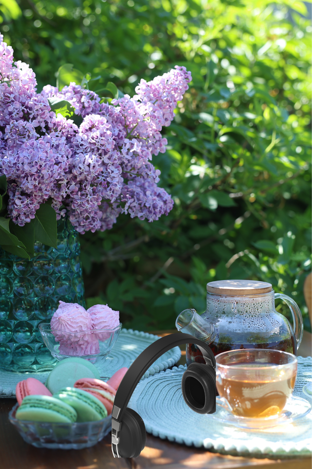 Bluetooth speaker on a garden table surrounded by summer flowers and a cold drink 