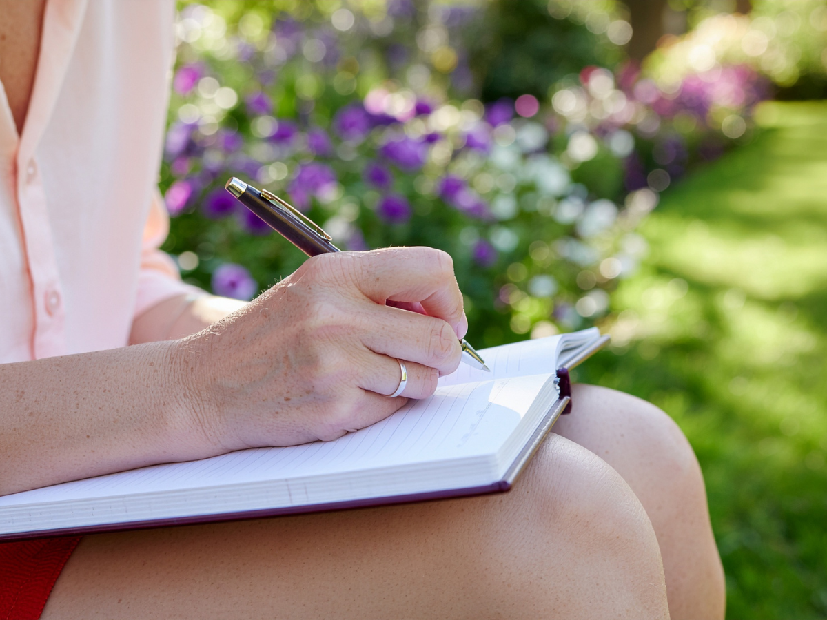 Woman sat measing up and writing down measurements for Garden furniture