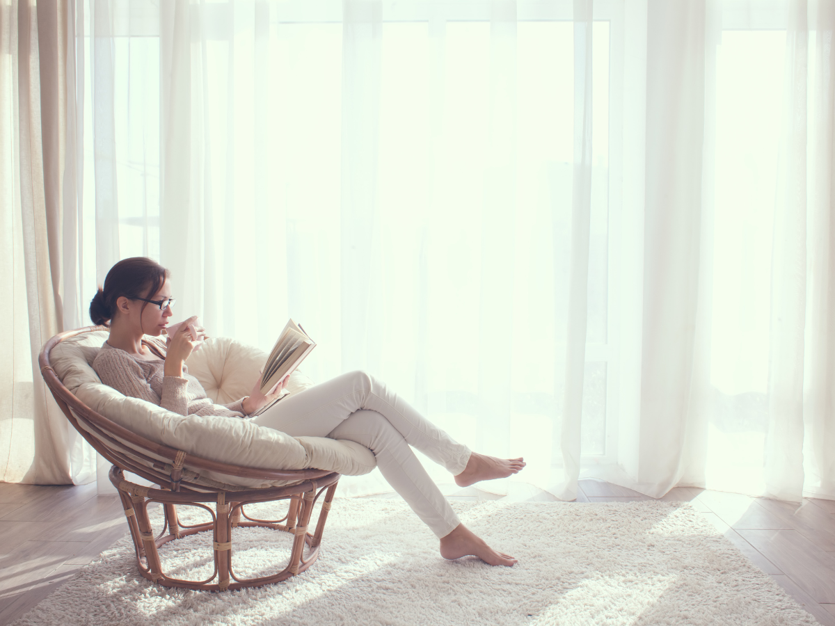 woman relaxing with a summer drink in a sunlit garden — summer staycation at home