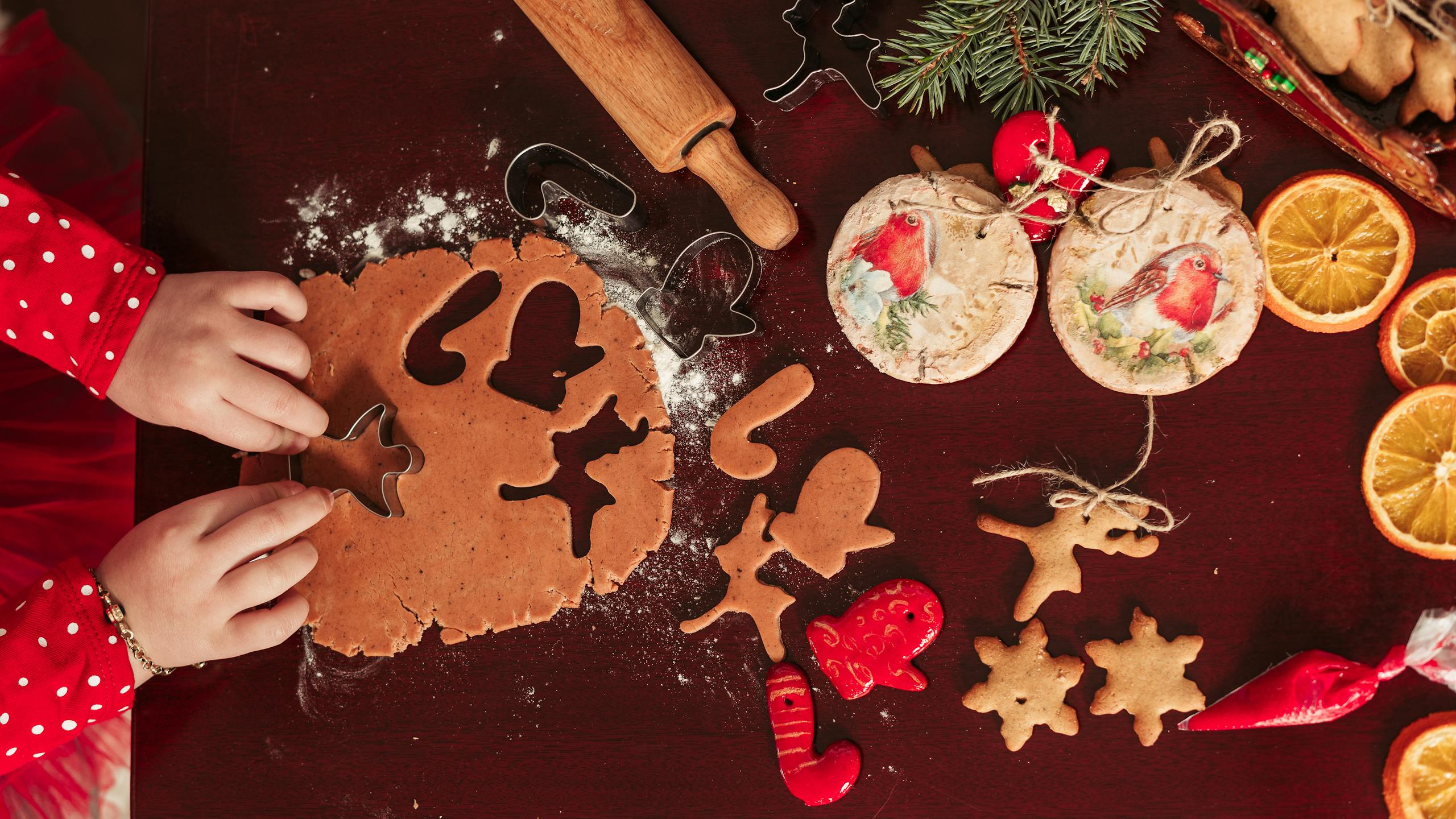 Child making holiday cookies with cutters and decorations. Perfect for Christmas festivities.