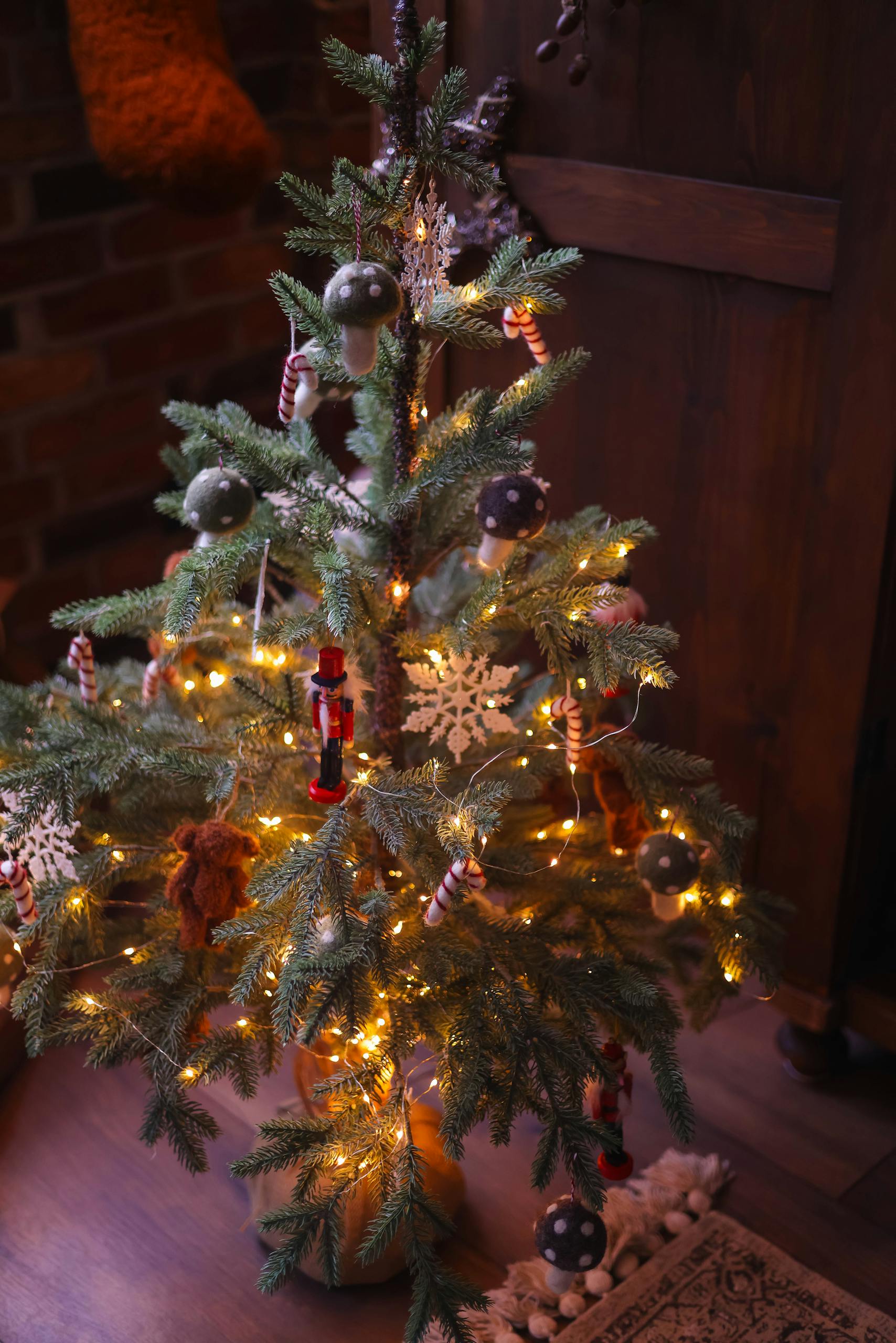 Festive Christmas tree adorned with lights and ornaments in a cozy living room setting.