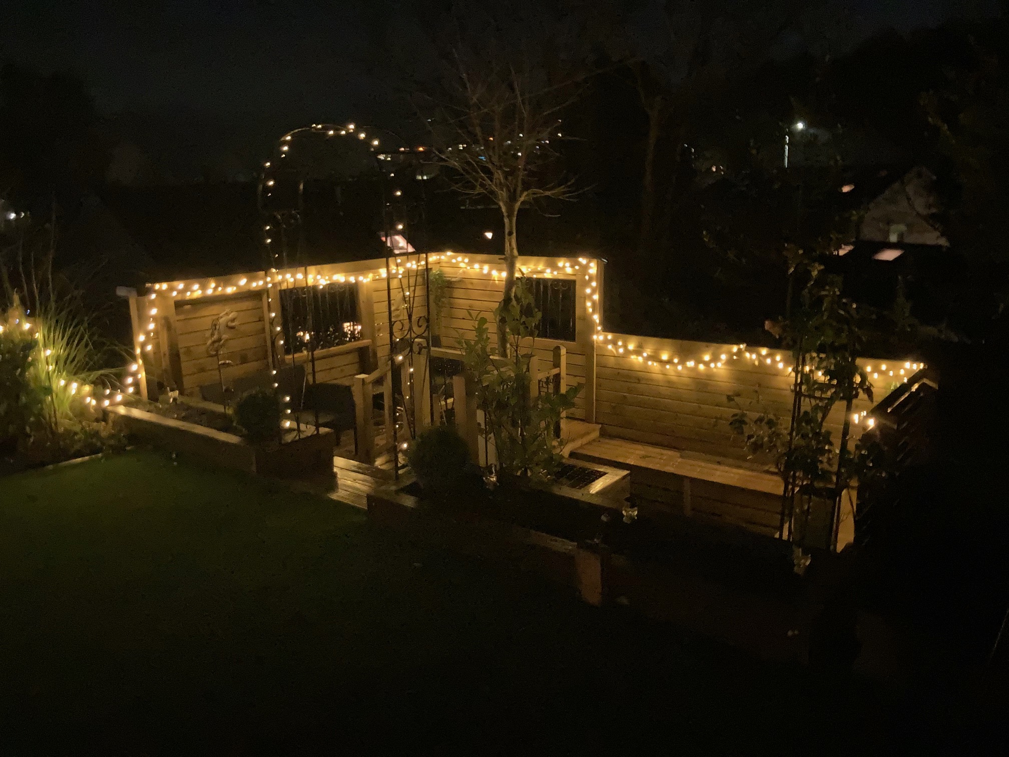 Fairy lights round a garden a patio at night
