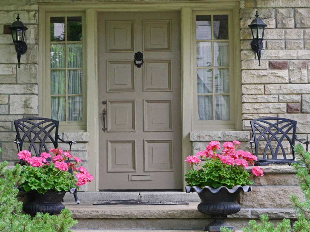 Vibrant flowers in pots on either side of front porch door for a summer makeover