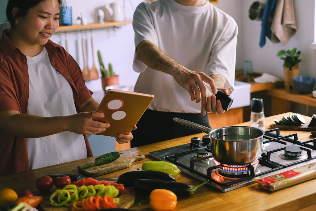 couple cooking together at home on a summer evening for a cosy night in summer 