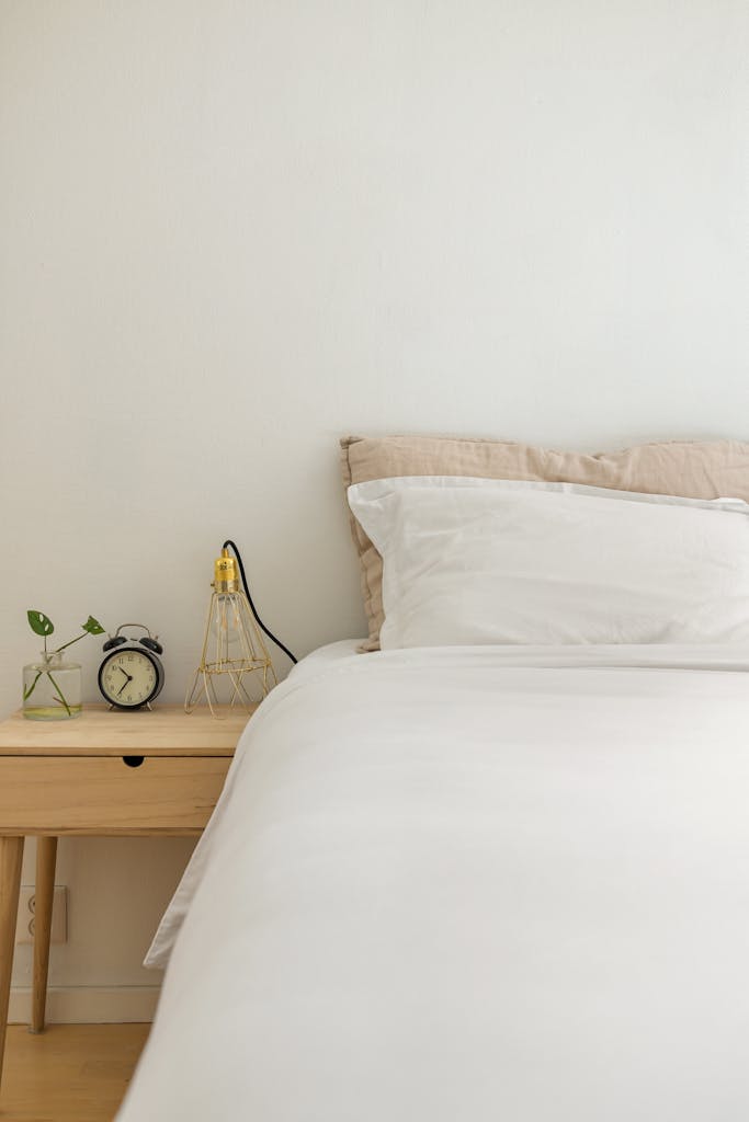 Clean white linen bed sheets on bed cool calm bedroom UK summer heatwave