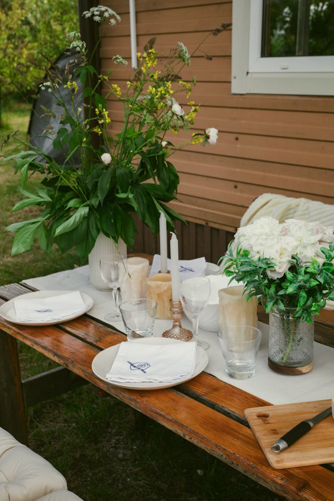 Rustic outdoor table setup with flowers, ideal for a cosy gathering.