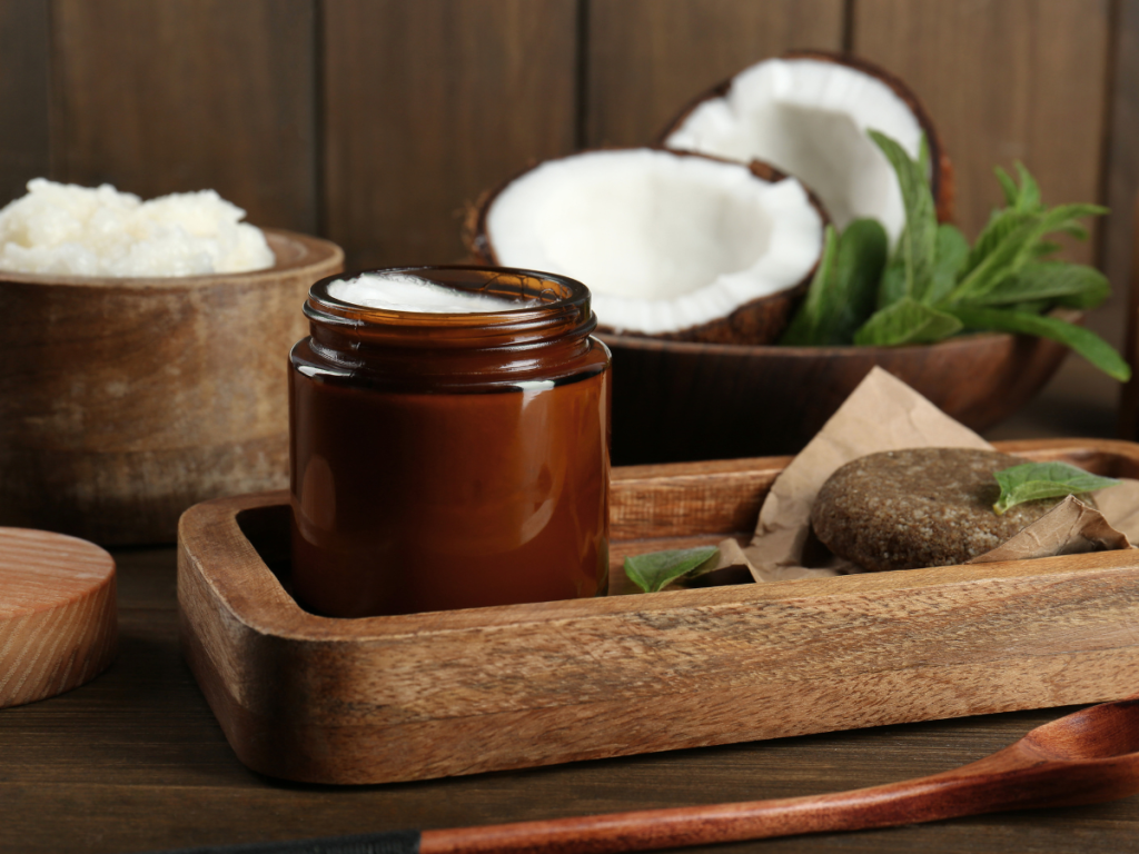 Homemade summer body scrub with coconut oil and lime in a glass jar next to fresh mint leaves — DIY summer spa treatment.