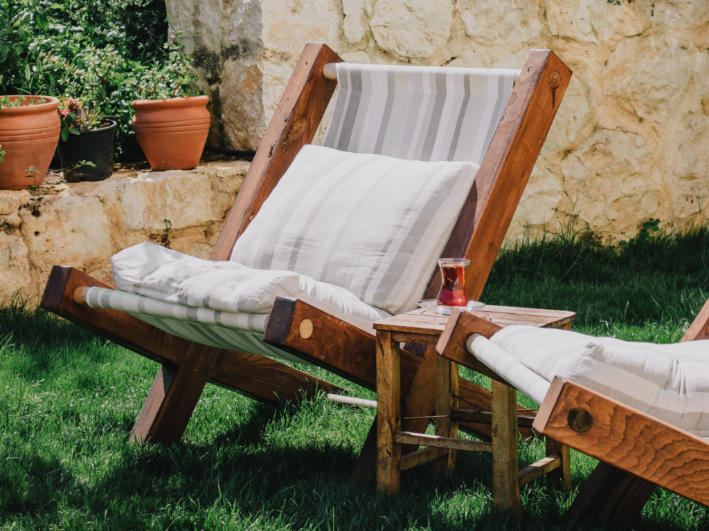 garden chair with stripped light linen lining with iced tea on table outdoor summer spa at home
