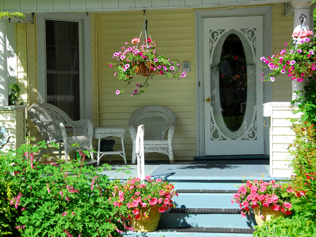 Finished front porch makeover with bench plants lights and doormat summer staycation feel