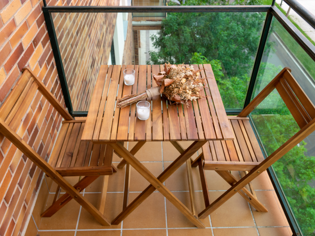 A small Balcony set up with wooden folding chairs and table for a staycation Sanctuary