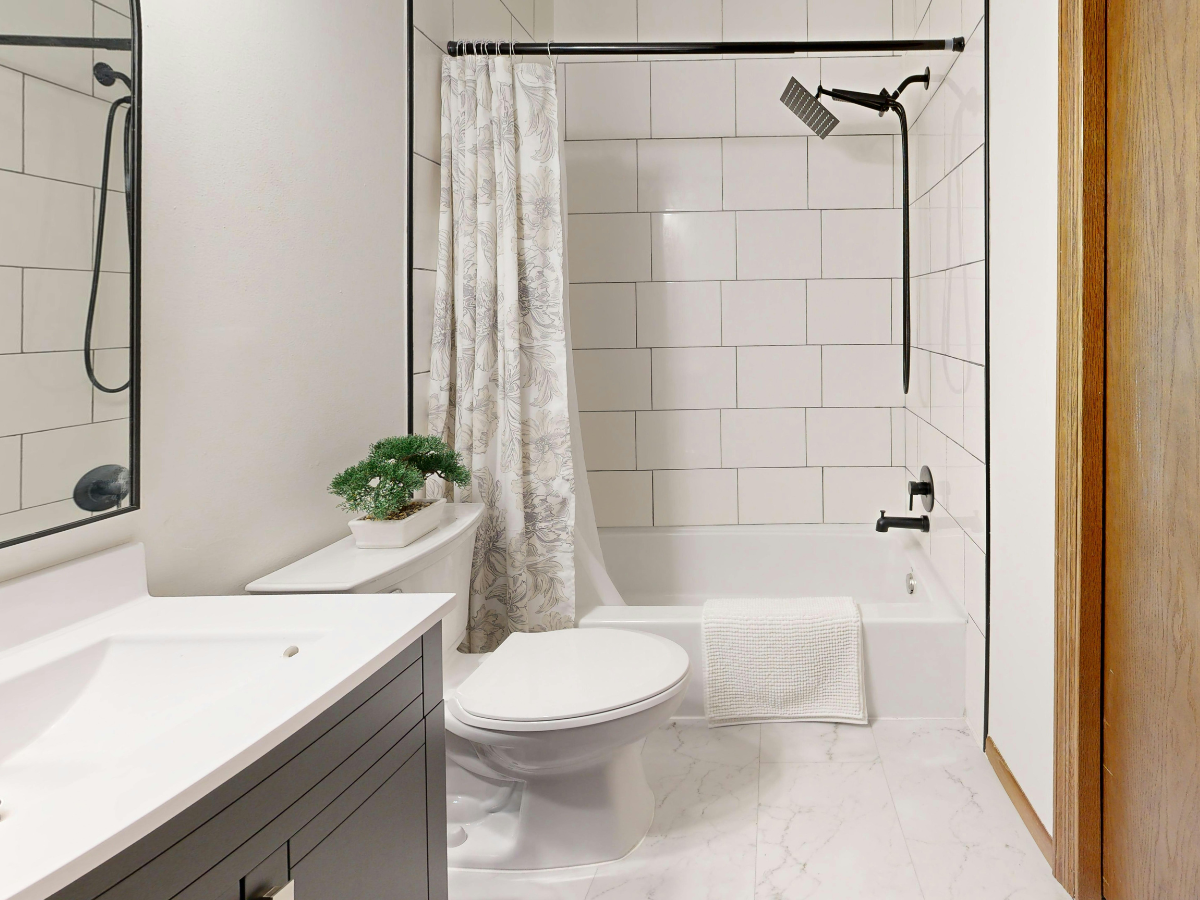 waffle texture shower curtain hanging in a clean simple bathroom in a newly moved into home — moving hacks to make your new home feel like a dream getaway