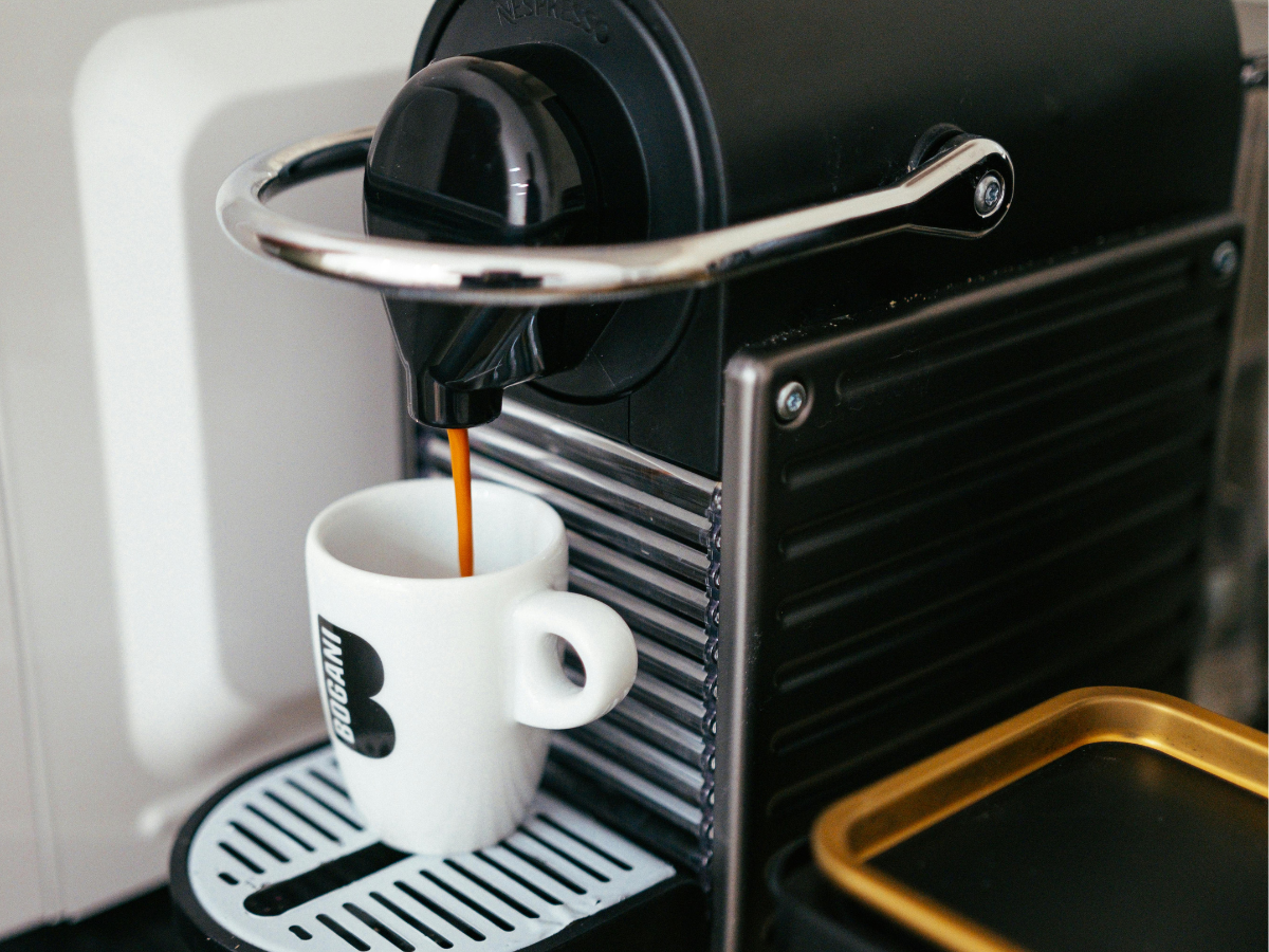Coffee machine pouring coffer into a single white mug