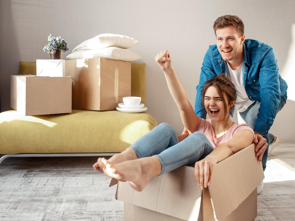 A couple having fun in an empty box after just moving into a new home.