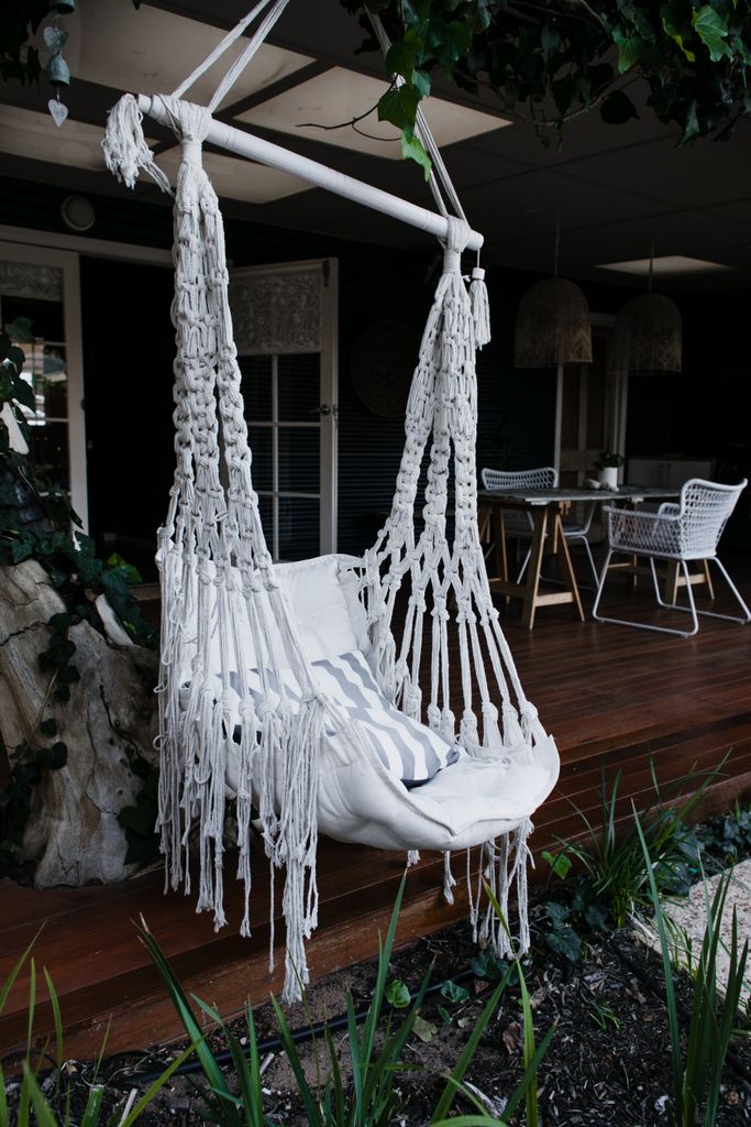 A woven hammock chair outdoors for a summer reading retreat at home, perfect for relaxation.