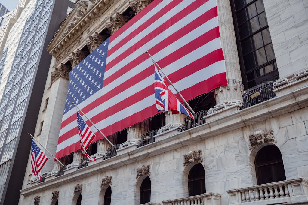 American flag and small UK flag on a historic building exterior symbolizing patriotism and national pride.