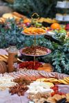 An elegant 3 tier grazing board with cold cuts, cheese, fruits, and nuts, perfect for special summer occasions.