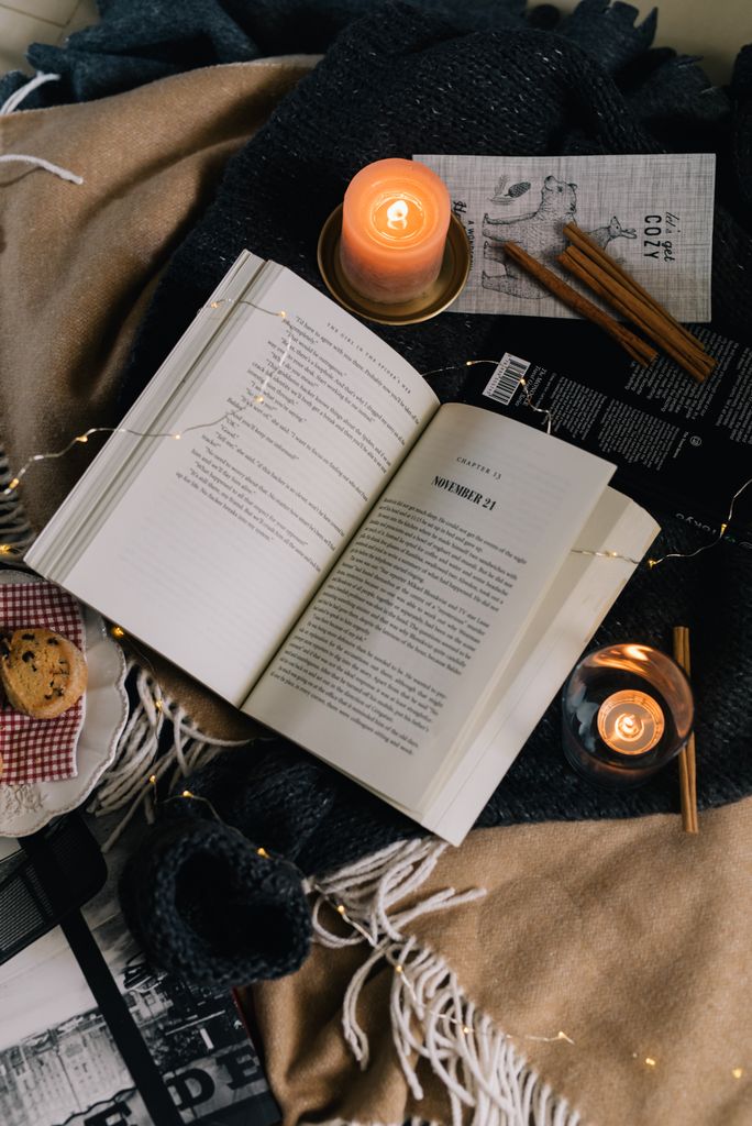 reading retreat at home setup with fairy lights candle and cosy blanket on armchair]