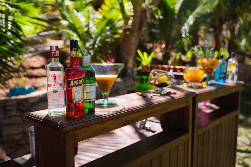 Outdoor DIY cocktail bar setup on a garden patio with fairy lights and fresh garnishes — summer entertaining at home