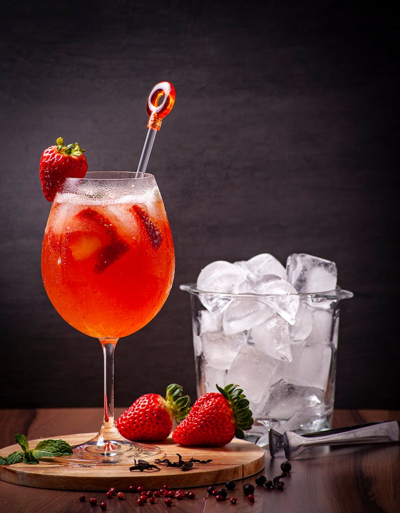 Large clear ice cubes in a glass bowl next to a DIY home cocktail bar setup in summer