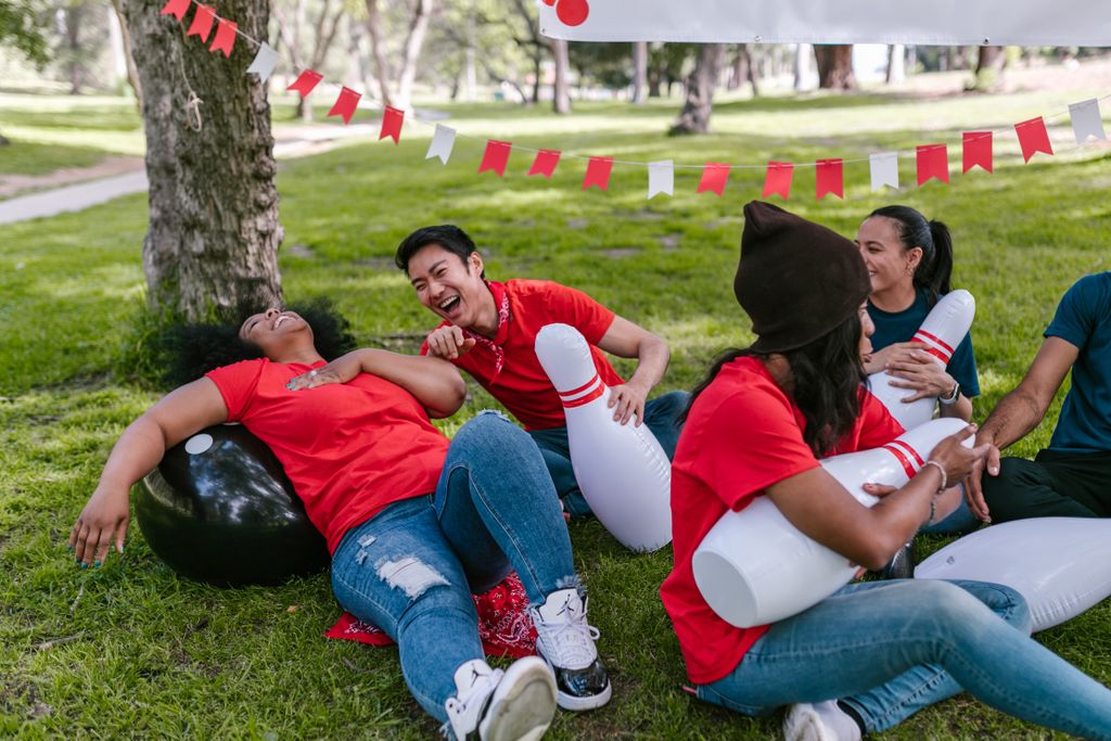 group of adults laughing playing garden games on a sunny day - play day at home for adults