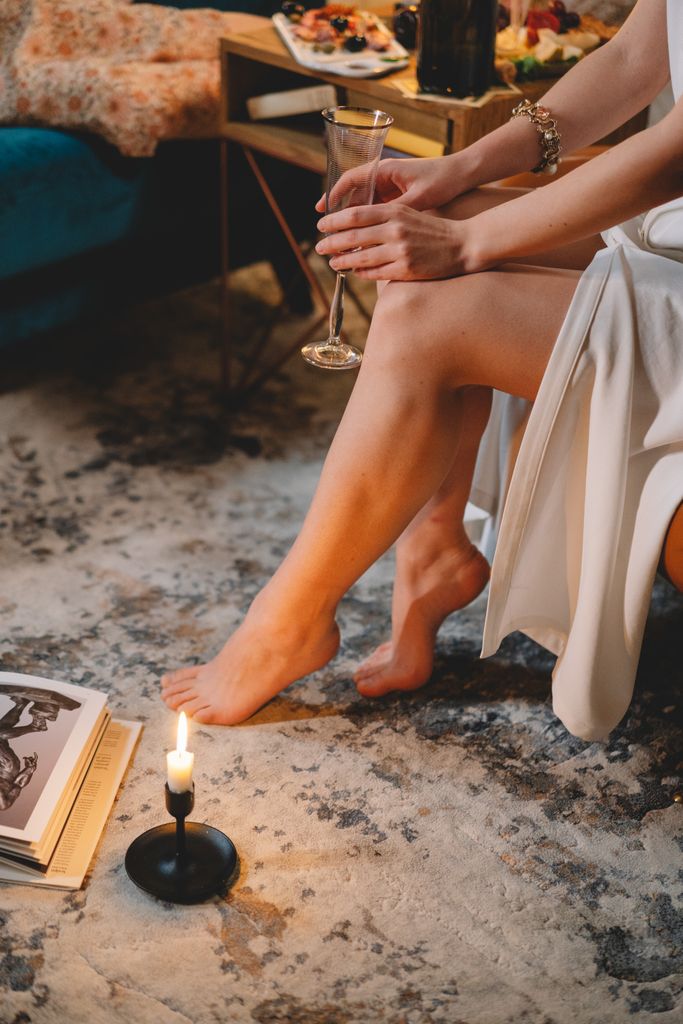 Elegant setting with a woman enjoying wine and candlelight indoors. Perfect for a cozy evening.